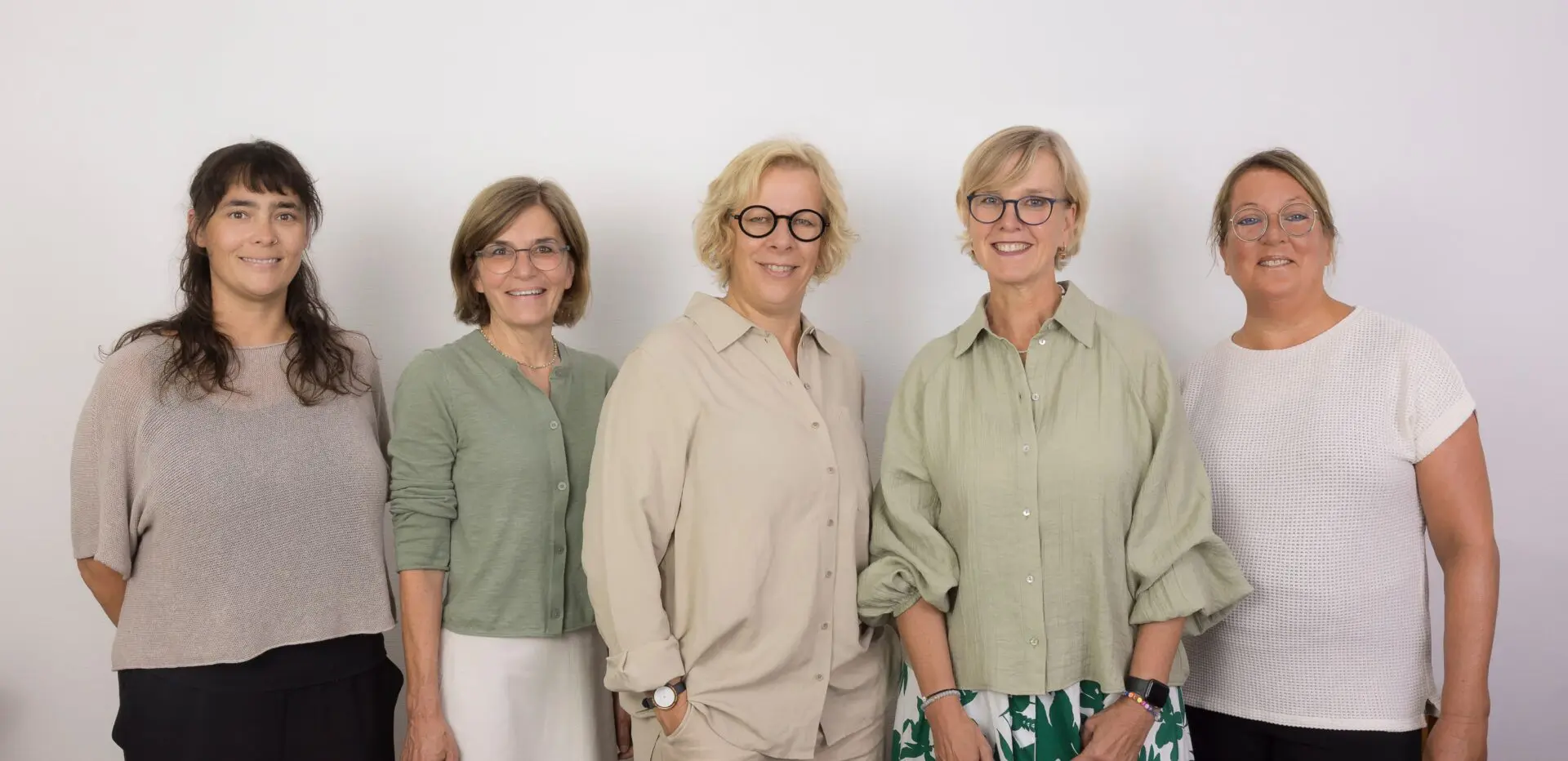 Arndt-Logopäd-Praxis-Barbara-2026-bestoff-web-8 Gruppenfoto der fünf Mitarbeiterinnen der Praxisgemeinschaft für Logopädie vor einer hellen Wand.